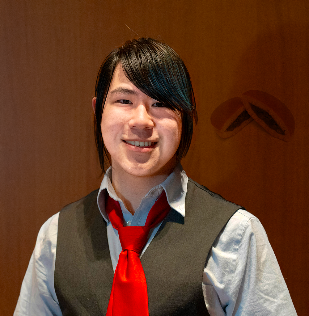 Jolly coworker poses in front of wooden wall. Dorayaki Apparation
